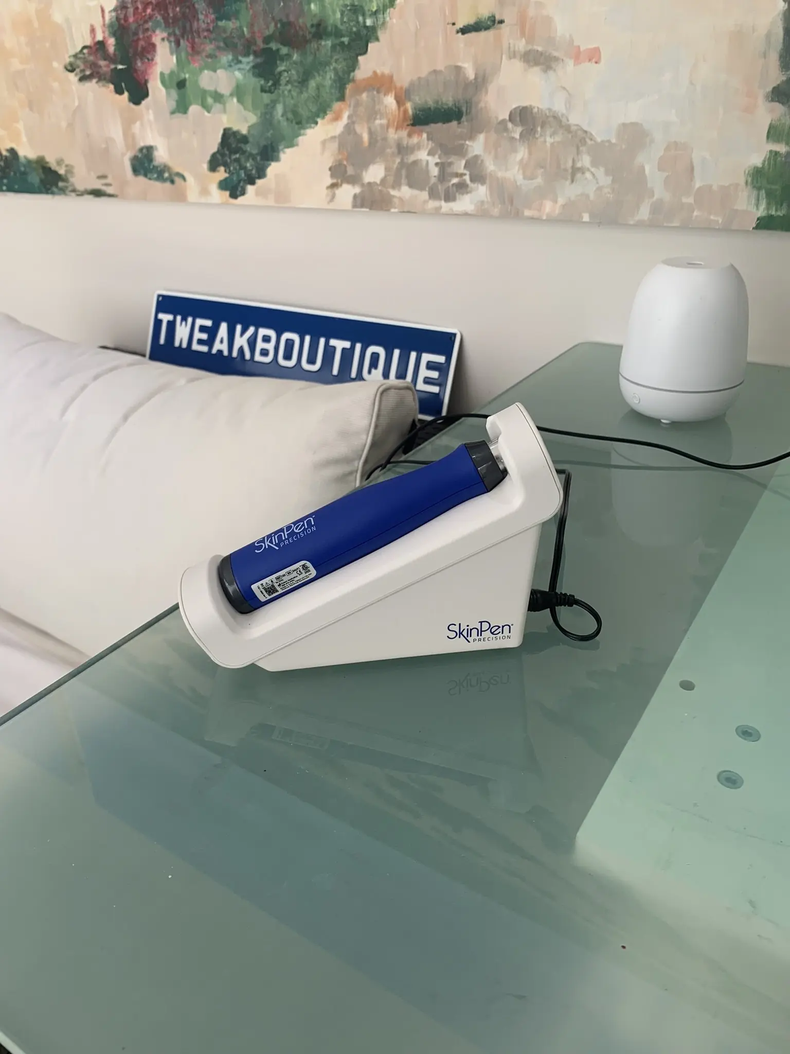 A SkinPen microneedling pen in its charging stand on the clinic desk